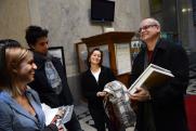 Tóth Tibor, miután a százezredik jegyet vásárolta meg a Szépművészeti Cézanne és a múlt című kiállítására, családjának mutatja a kapott ajándékokat.  