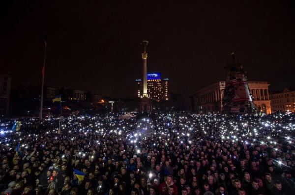 Résztvevők mobiltelefonjaikkal világítanak az összecsapások áldozatainak emlékére rendezett gyászszertartáson a Majdanon