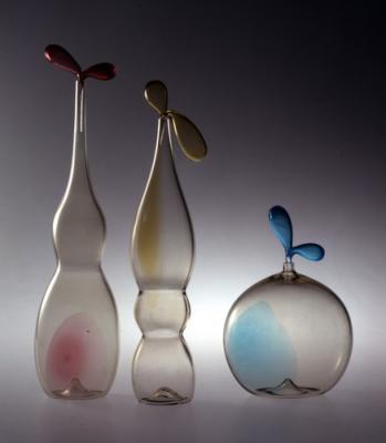 Zefiro palackok, átlatszó fumé (füstös) üvegből, melegen formázva, rubin színű
cirmokkal.<br>
Tervezte: Luciano Gaspari<br>
Kivitelezte: Esecuzione Salviati and C. 1982